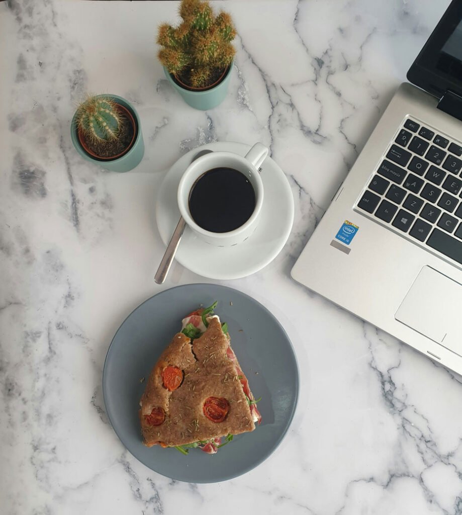 Laptop with Sandwich and Coffee Cup on Desk